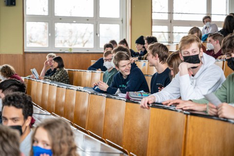 Personen in einem Hörsaal unterhalten sich. 