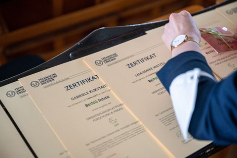 Eine Hand, welche gerade die Zertifikate vorbereitet.