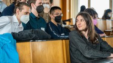 Mehrere Personen in einem Hörsaal unterhalten sich miteinander.