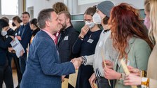 Personen bekommen ihre Zertifikate überreicht, dabei wird ihnen durch Händeschütteln gratuliert.