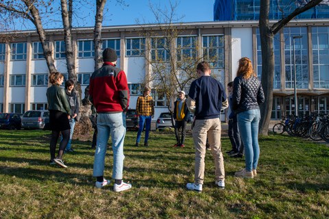 Eine Gruppe auf einer Wiese im Kreis.