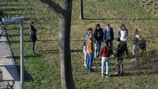 Personen stehen im Kreis auf einer Wiese. 