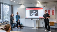 Drei Personen halten einen Vortrag mit einer Power Point Presentation. 