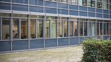 Foto der Gruppenräume von draußen fotografiert. Man sieht hinter den Fenstern einige Studierende beim Arbeiten.