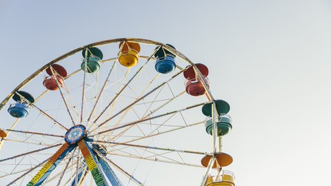 photograph of a colourful merry-go-round, photograph is taken from below