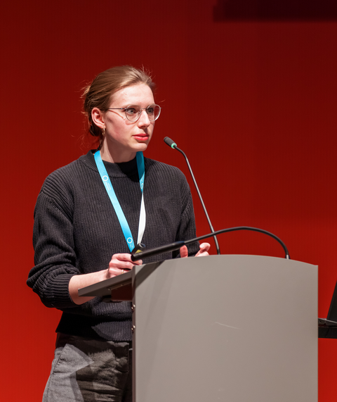 Kollegiatin Marie Walstab steht am Rednerpult und lauscht den Fragen und Anregungen der Teilnehmenden.