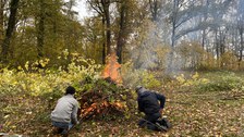 Zwei Studierende entfachen ein Feuer.