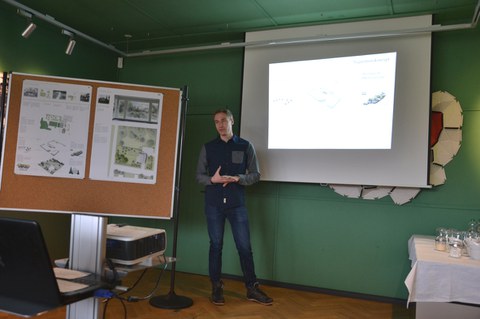Foto zeigt eine Präsentation eines Studenten, welcher seine Arbeit präsentiert.
