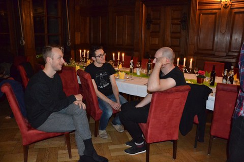 Foto zeigt Studenten im abendlicher Runde im Speisesaal des Schlosses in Thammenhain.