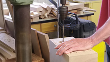 Bild eines Holzblockes in dem Löcher gebohrt werden
