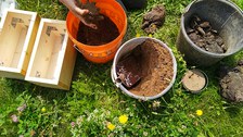 Bild von mehreren Eimern, gefüllt mit Mörtel und Sand.