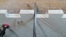 Detailfoto eines Holzelementes im Bauprozess mit Hand und Werkzeug
