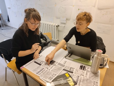 Lehrende und Studierende an einem Tisch