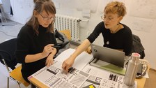 Lehrende und Studierende an einem Tisch