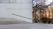 Foto vom Vorplatz des Hörsaalzentrums mit einem Teil der Treppe und dem Beyer-Bau im Hintergrund.