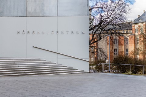 Foto vom Vorplatz des Hörsaalzentrums mit einem Teil der Treppe und dem Beyer-Bau im Hintergrund.