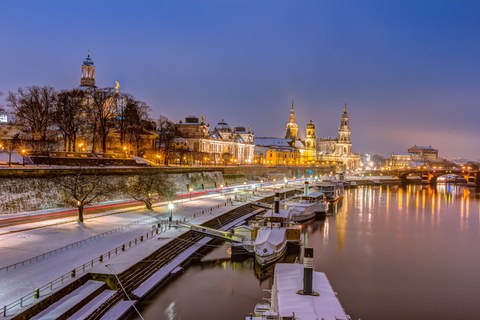 Das Foto von der verschneiten beleuchteten Elbterrasse mit Dampfer und Frauenkirche im Abendrot.