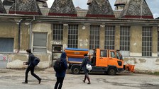 Studierende vor einem altem Industriegebäude