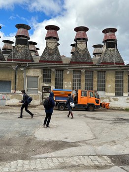 Studierende vor einem altem Industriegebäude