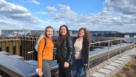 Drei Frauen auf dem Dach eines Hauses vor dem Wolkenhorizont