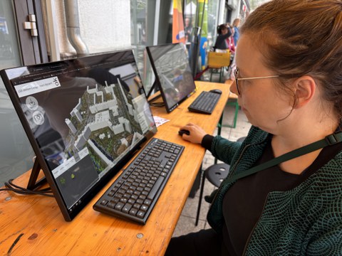 Besucherin vor dem Bildschirm mit dem Co-Design-Tool U_CODE