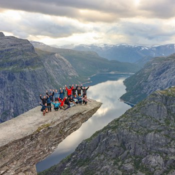 Foto zeigt die Exkursionsgruppe wagemutig auf dem Trolltunga-Felsen