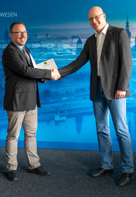Prof. Löhnert congratulates Dr. Schlebusch on the 25th employment anniversary