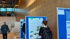 A conference participant is reading through the BIBOB poster.