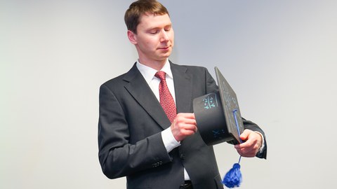 Doktorand betrachtet seinen Doktorhut