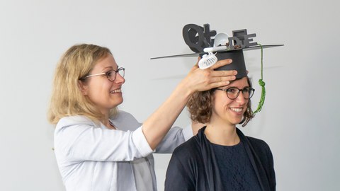 Doktorantin bekommt Promotionshut