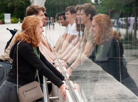 Gesichter spiegeln sich in einer Glasscheibe