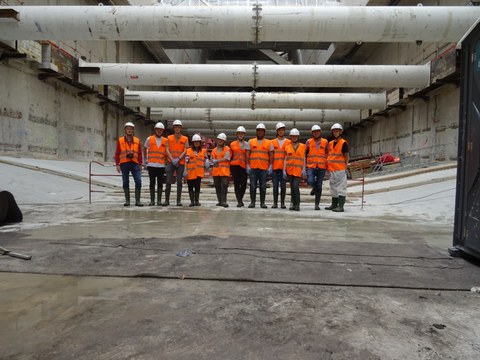 Die Gesamte Reisegruppe hat sich für ein Gruppenfoto auf einer großen Betonbaustelle aufgestellt