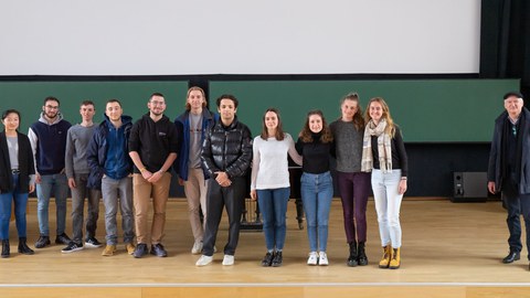 Alle Studierenden des Doppeldiplomprogramms stehen zu einem Gruppenbild auf der Bühne des Hörsaals