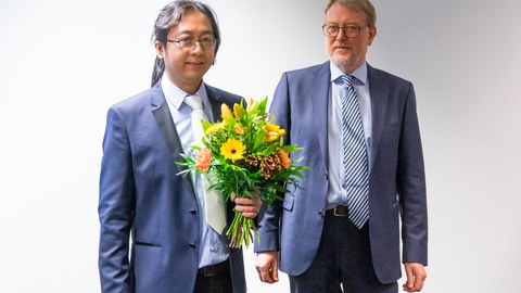 Professor Kaliske übergibt Blumen an den Doktoranden