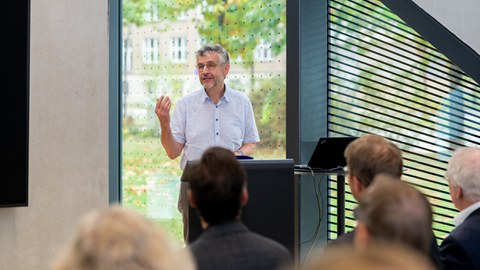 Redner steht im Cube vor den Zuhörern