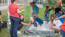 Ein Bad im Stärkewasser, viele Kinder stehen in der Wanne