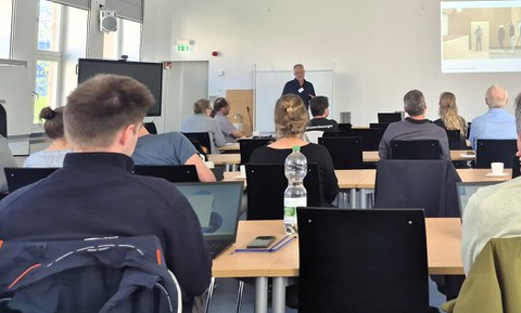 Prof. Henning Haupt trägt vor dem Publikum vor.