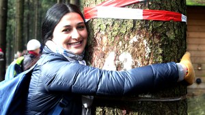 A participant is hugging a tree during an excursion