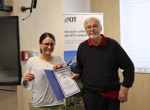Romy Rehschuh hält eine Urkunde in der Hand, die ihr vom rechts nebenstehenden ehemaligen Institutsleiter Prof. Dr. Wolfgang Seiler gerade übergeben wird
