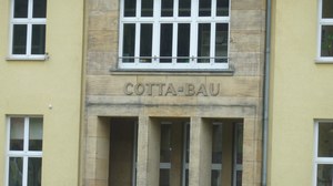 The photo shows the lettering COTTA-BAU above the entrance area of ​​the building mentioned
