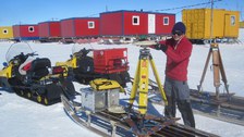 Vorbereitung der kinematischen GPS-Ausrüstung für unsere Profilmessungen. Im Hintergrund sind die Wohncontainer von Novo Airbase zu sehen.
