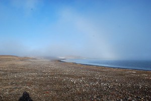 Herbsttag in Nordgrönland. Die Sonne zeichnet einen Nebelbogen auf den leichten Nebel. 