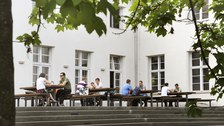 Ansicht der Außenterasse der Alten Mensa, Studierende verbringen gerade ihre Mittagspause