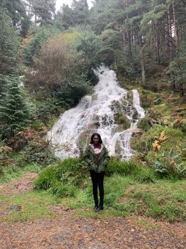 Projektpartnerin steht vor Wasserfall