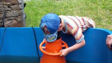 Kind guckt mit Wassergucker in Schwimmbecken