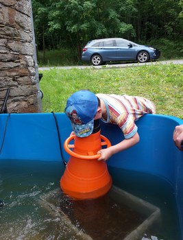 Kind guckt mit Wassergucker in Schwimmbecken