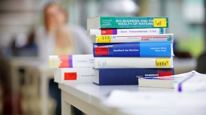 Fachbücher liegen gestapelt auf einem Tisch