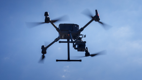 Foto einer fliegenden Drohne am blauen Himmel