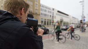 This picture shows a person measuring traffic speeds.