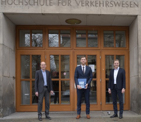 Drei Männer stehen vor dem Eingang zur Fakultät Verkehrswissenschaften